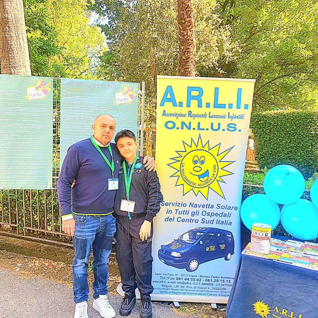 Volontario A.R.L.I. accanto a un bambino durante un'iniziativa solidale